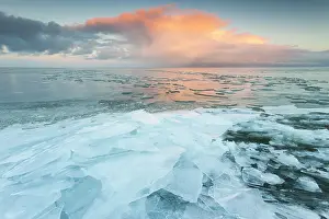 Drifting: Hummocking ice on the shore in sunrise