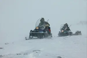 Snowmobiles: Hunters - on snowmobiles, tracking polar bear through