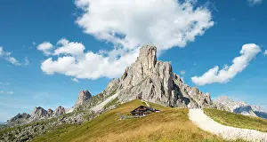 Hiker: Hut at Passo Giau with La Gusela peak, Averau, Dolomites