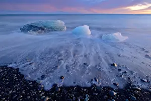 Jokulsarlon: Ice on the black volcanic beach during sunset i