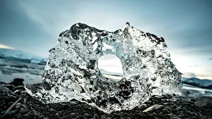 Gravel: Ice, ice chunks with hole at the black gravel beach