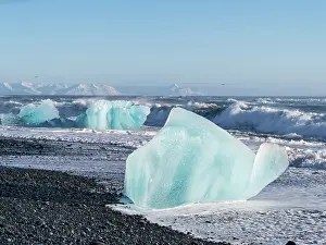 Cemetery: Iceberg on black volcanic beach. North Atlantic