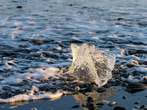 Cemetery: Iceberg on black volcanic beach. North Atlantic