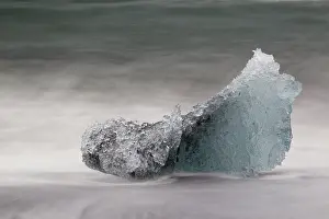 Beache: Iceblock on the beach with splashing seawater