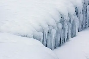 Seljalandsfoss: Icicles hanging over snow