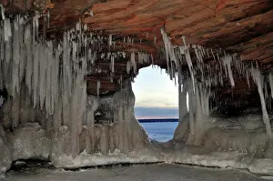 Lakeshore: Icicles and ice formations in a cave and view through