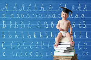 Board: Infant wearing a graduation cap sitting on a pile