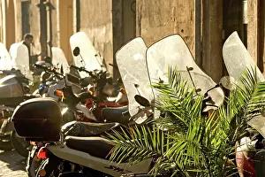 Motorbike: Italy - Rome - street scene with parked mopeds in sunlight
