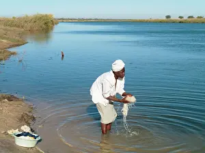 Angola: Kavango woman washing clothes at the Namibian side