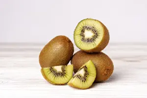 Isolated: Kiwi slices on white wooden table