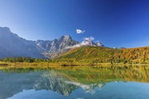 Journey: Lake Almsee in autumn with a forest reflected in the lake
