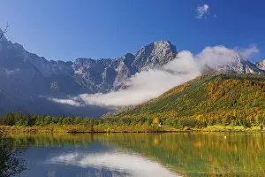 Journey: Lake Almsee in autumn with a forest reflected in the lake