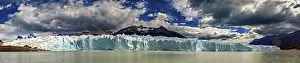 Glaciers: Large-scale panorama of a distant glacier with draped clouds and mountains