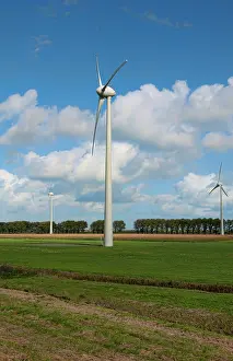 Mills: Large wind mills generating energy in farmland