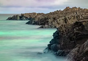 Lava: Lava rocks along tranquil shoreline of San Cristobal