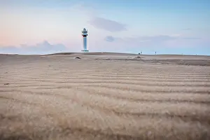 Sergio Arias: Lighthouse at sunrise with dunes