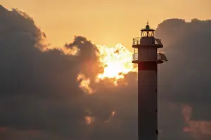 Sergio Arias: Lighthouse at sunrise with the sun behind the clouds