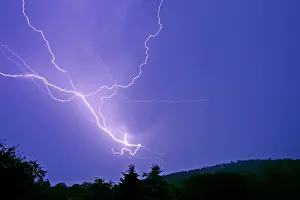 Thunder: Lightning and thunder clouds - over woodland at night