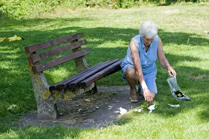 Anti: Litter - Woman picking up rubbish left by previous