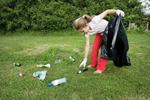 Discarded: Litter - Ten year old girl with black bin bag picking