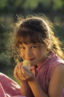 Smiles: Little girl holding a chicken in his hands