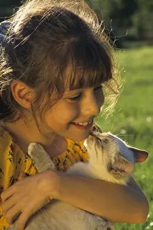 Smiles: Little girl holding a kitten in his hands