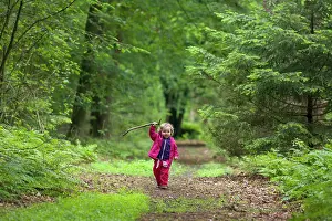 Garderen: Little girl playing with stick in forest