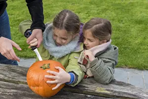 Making: Little girls making a Halloween pumpkin