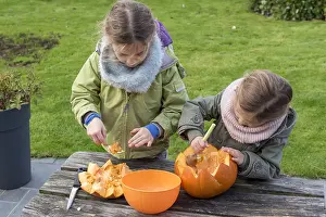 Making: Little girls making a Halloween pumpkin