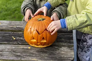 Making: Little girls making a Halloween pumpkin