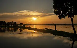 Boats: A lone fisherman on a lake at sunset with vibrant colors-Dhaka