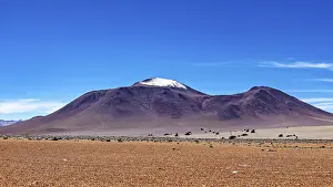Lonesome: A lonely, snow-covered mountain rises from a dry