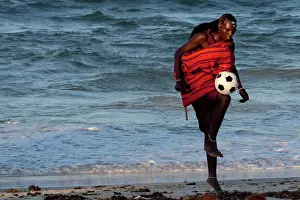 Rests: Maasai Tribesman - rests playing football after