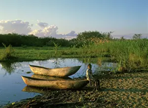 Malawi: Malawi - young boy by boat on shore of Lake Malawi