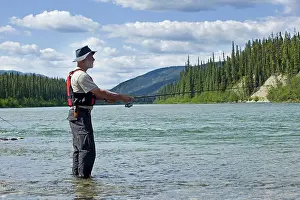 Bodies: Man fishing upper Liard River, standing in shallow