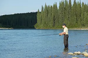 Bodies: Man fishing upper Liard River, standing in shallow