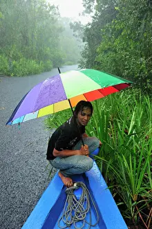 Guide: Man - guide on the boat with heavy rain on the