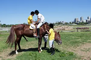 Saddle: Man helping a child to perform a balancing act