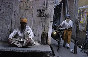 Towns: Man holding a dog sitting on his lap Amritsar India
