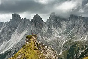 Mountaineer: Man with red jacket standing on one degree, behind