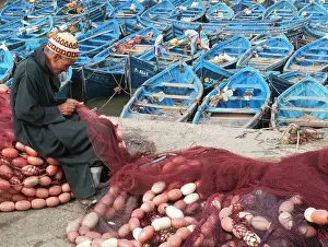 Attractive: Man repairing fishing nets in the fishing port