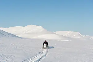 Motor: Man on snowmobile on it's way at Spitsbergen