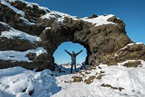 Krafla: Man standing in front of a rocky arch, lava field