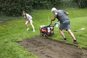 Cotswolds: Man and teenage girl using machine to cut turf from