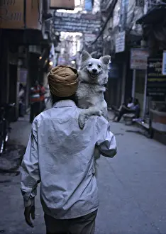 Headdress: Man walking in the street carrying hisr dog Amritsar India