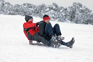 Sledging: Man and woman sledging in deep snow