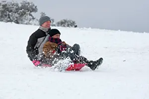 Sledging: Man and woman sledging in deep snow