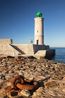 Beacon: Two men walking below the Cassis Lighthouse