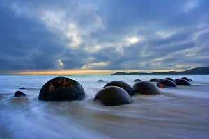 Incoming: Moeraki Boulders - massive spherical rocks at dawn