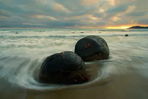 Incoming: Moeraki Boulders - massive spherical rocks at dawn